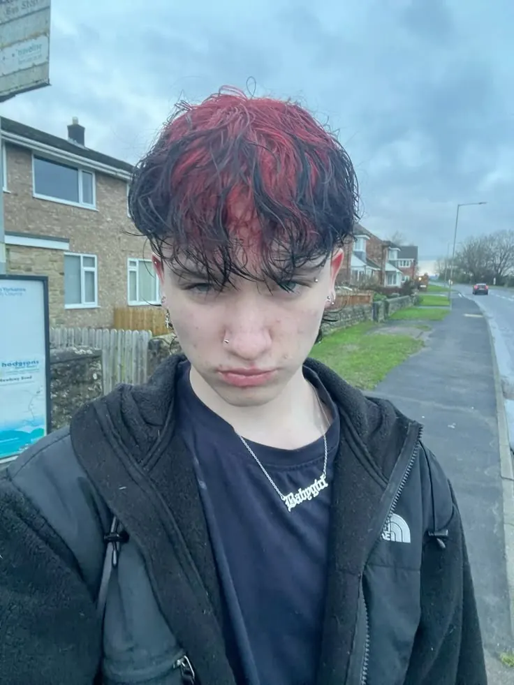 black men's wet fringe cut with burgundy red ghost roots.
