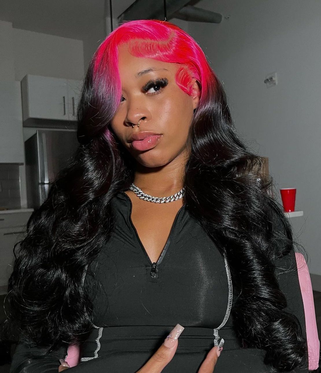 Long black glam waves with hot pink ghost roots and a side-swept front section.