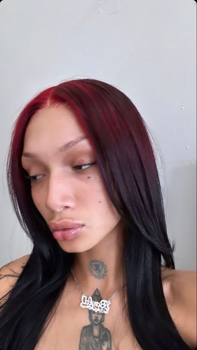 Straight black hair with a burgundy-red ghost-root panel and soft middle part.