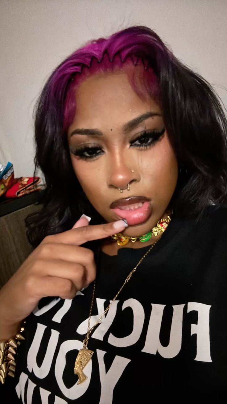 Black wavy hair with deep violet ghost roots and a soft middle part.