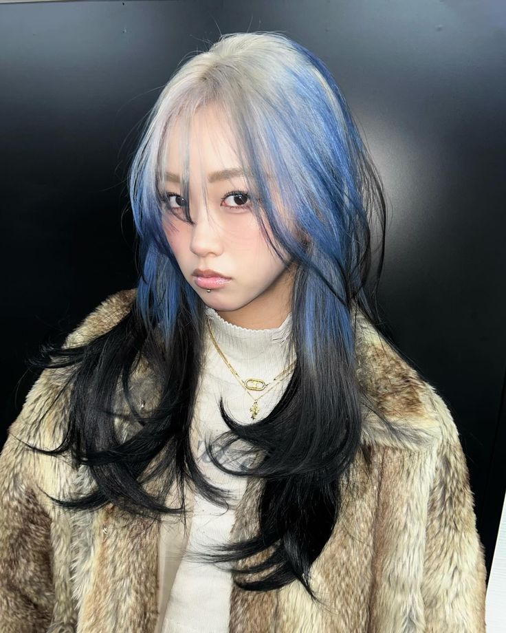 Long black layers with icy silver-blue ghost roots and airy face framing.