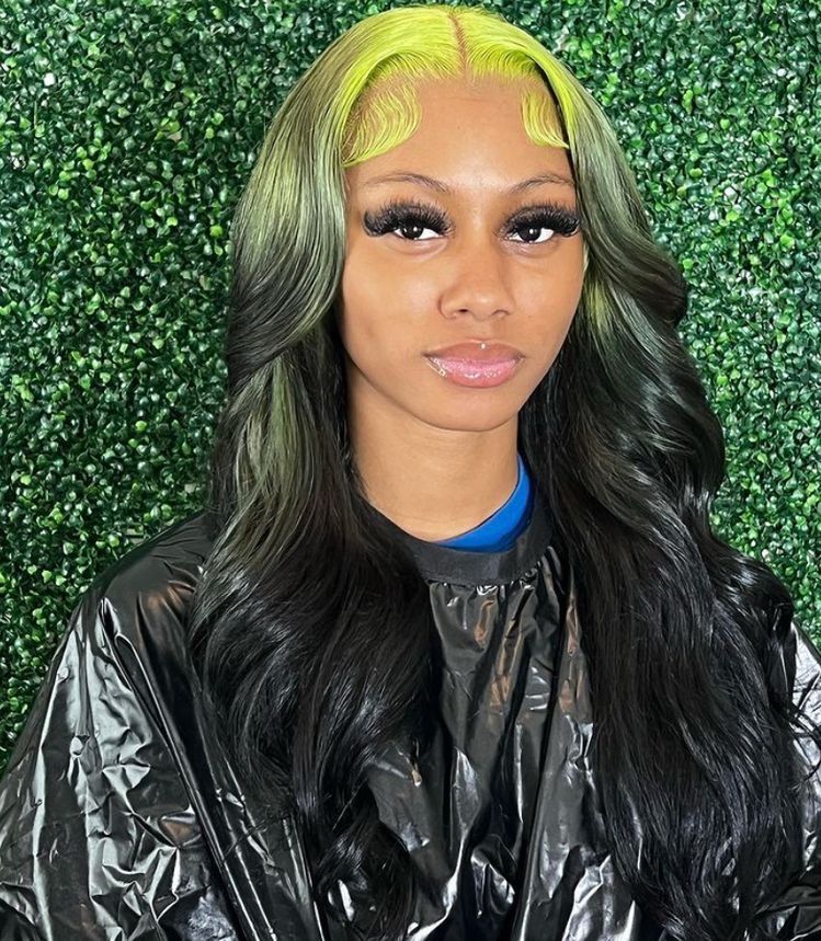 Long black waves with neon lime ghost roots and sculpted baby hairs.