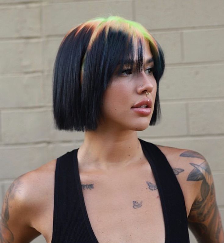 Glossy black bob with blonde and chartreuse ghost roots and full fringe.