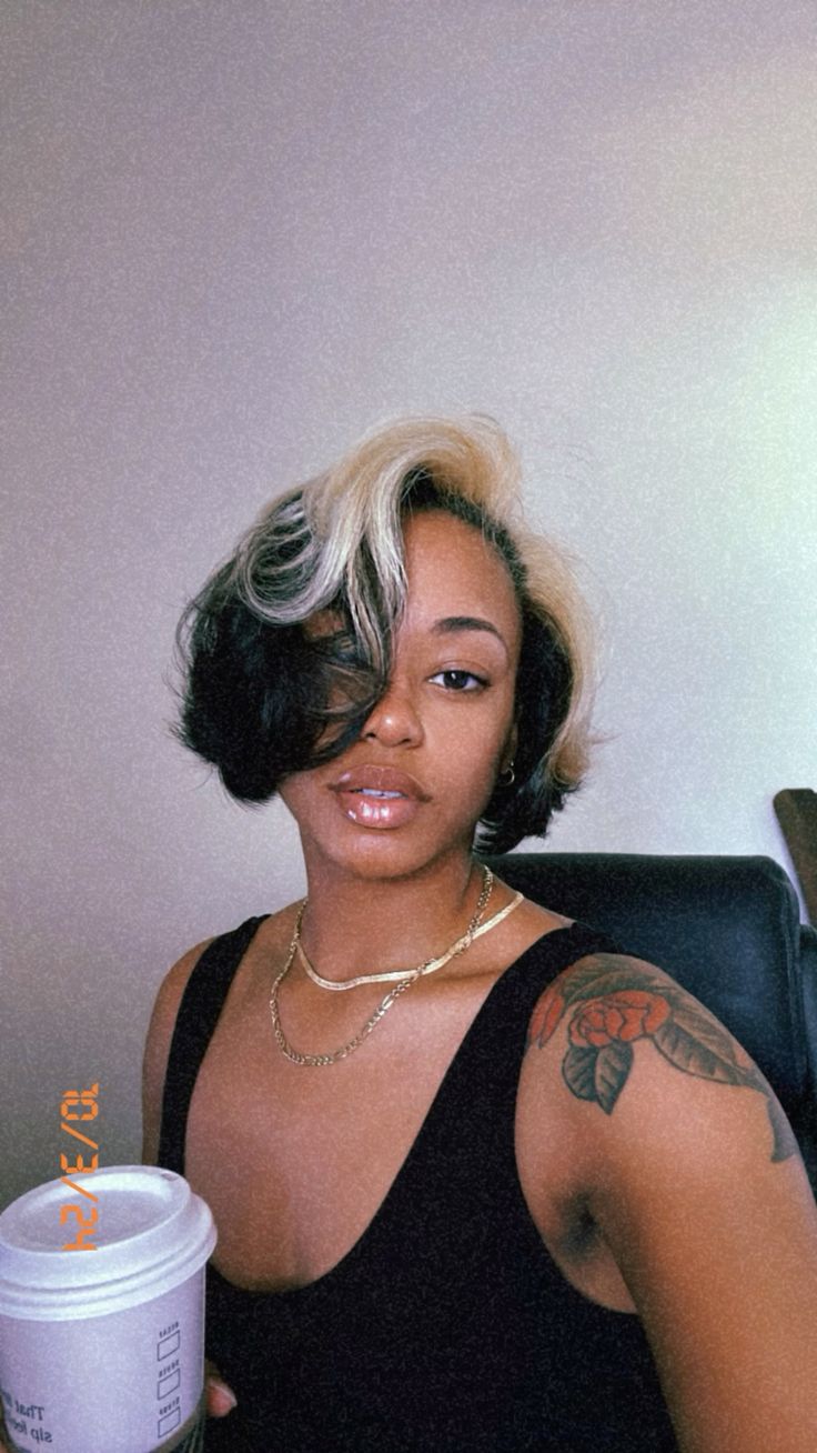 Short black vintage bob with platinum blonde ghost roots and a sculpted side part.