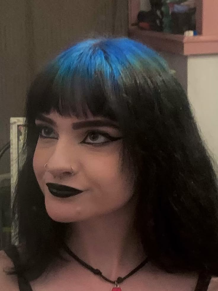 Long black hair with cobalt blue ghost roots and blunt fringe.