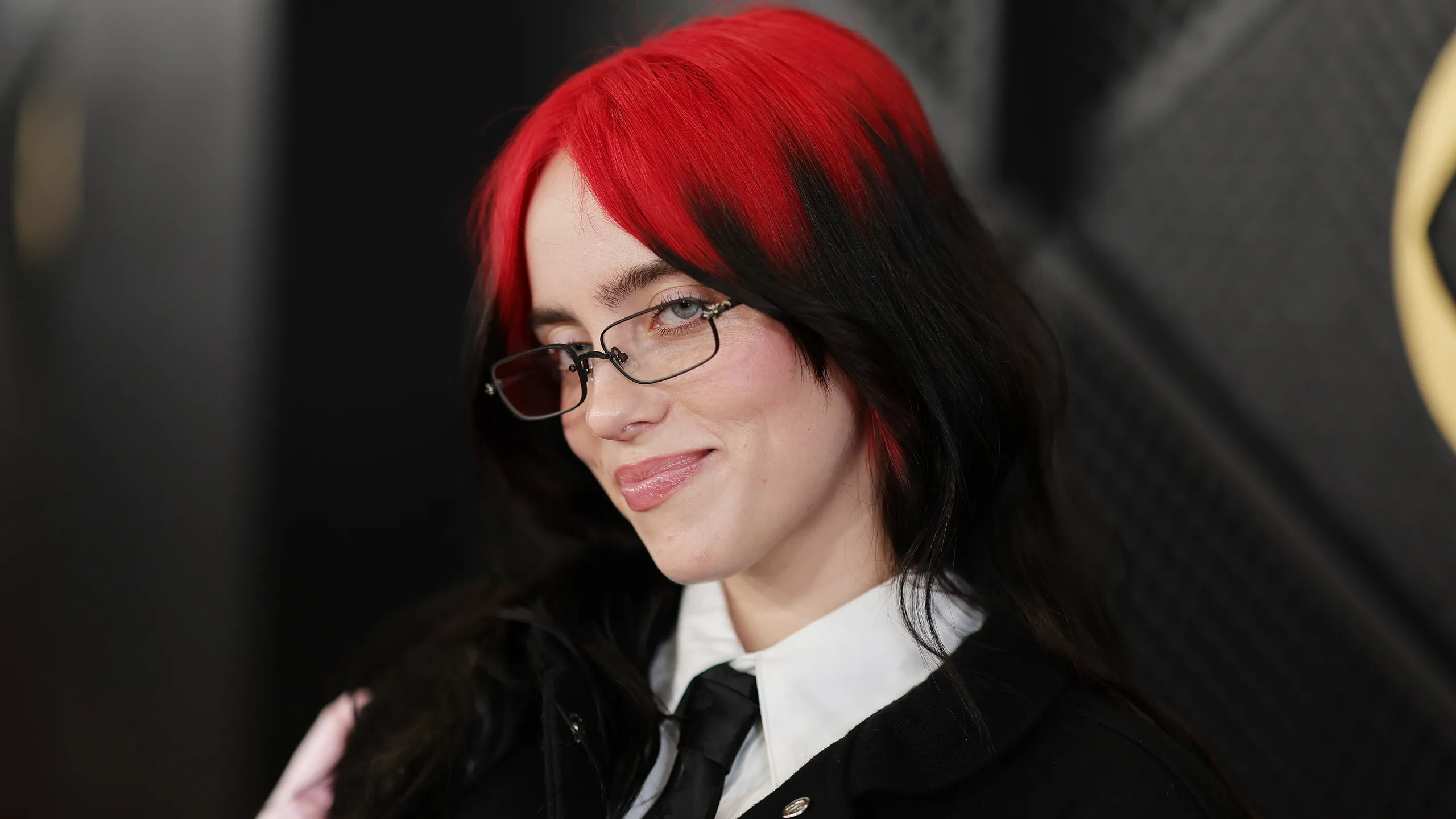 Long black hair with cherry red ghost roots and a soft middle-part shape.