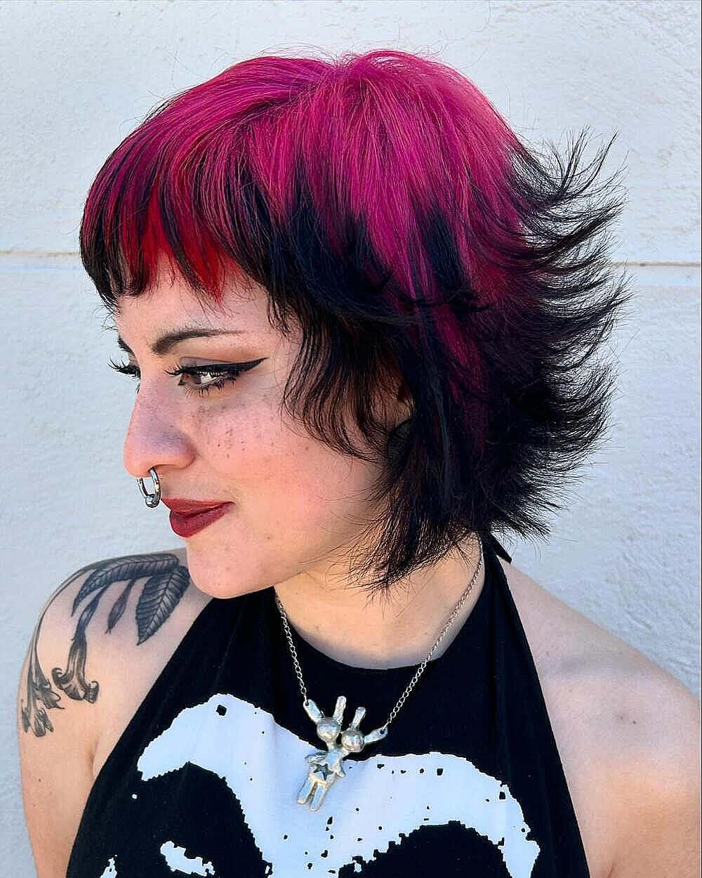 Magenta shag haircut with black underlayers and a choppy short fringe.