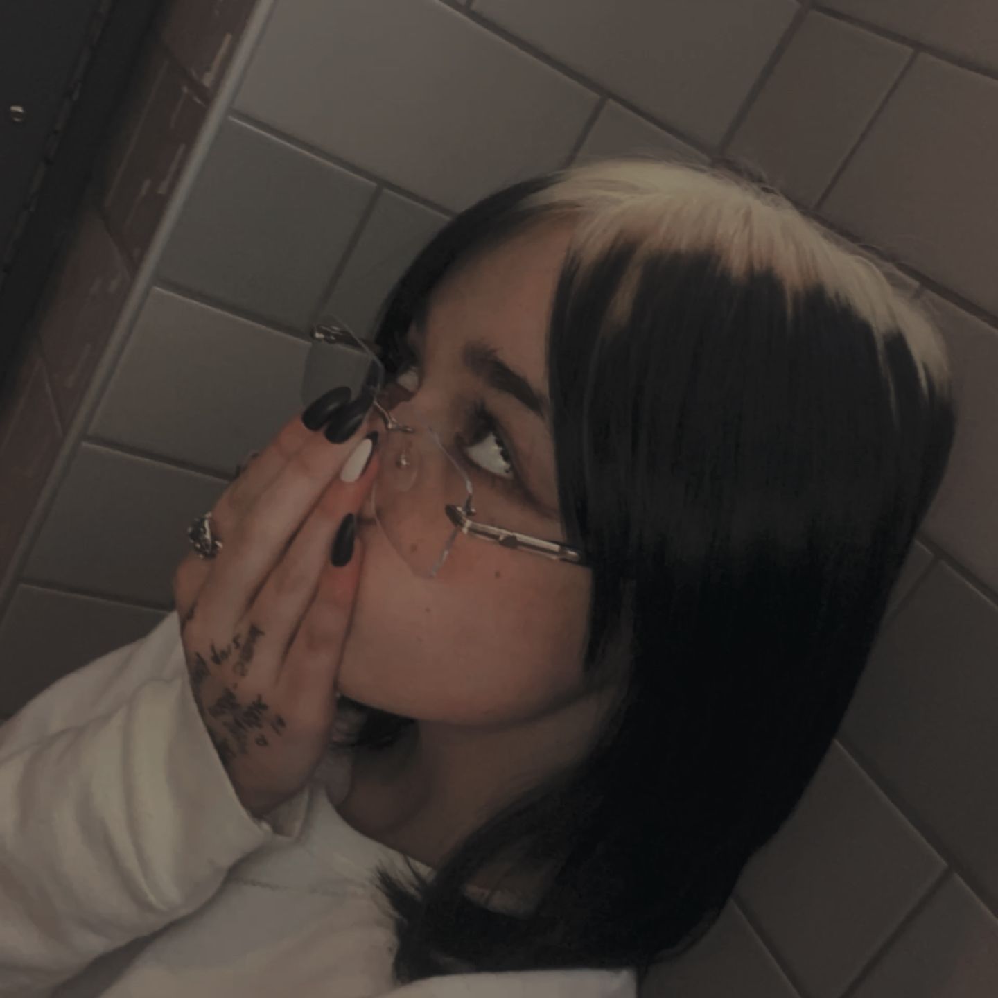 Black bob with creamy blonde ghost roots and a blunt face-framing fringe.