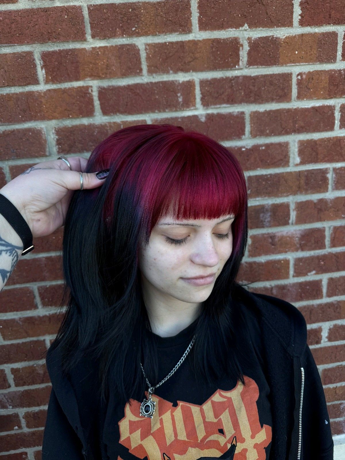 Long black hair with wine-red ghost roots and a blunt micro fringe.