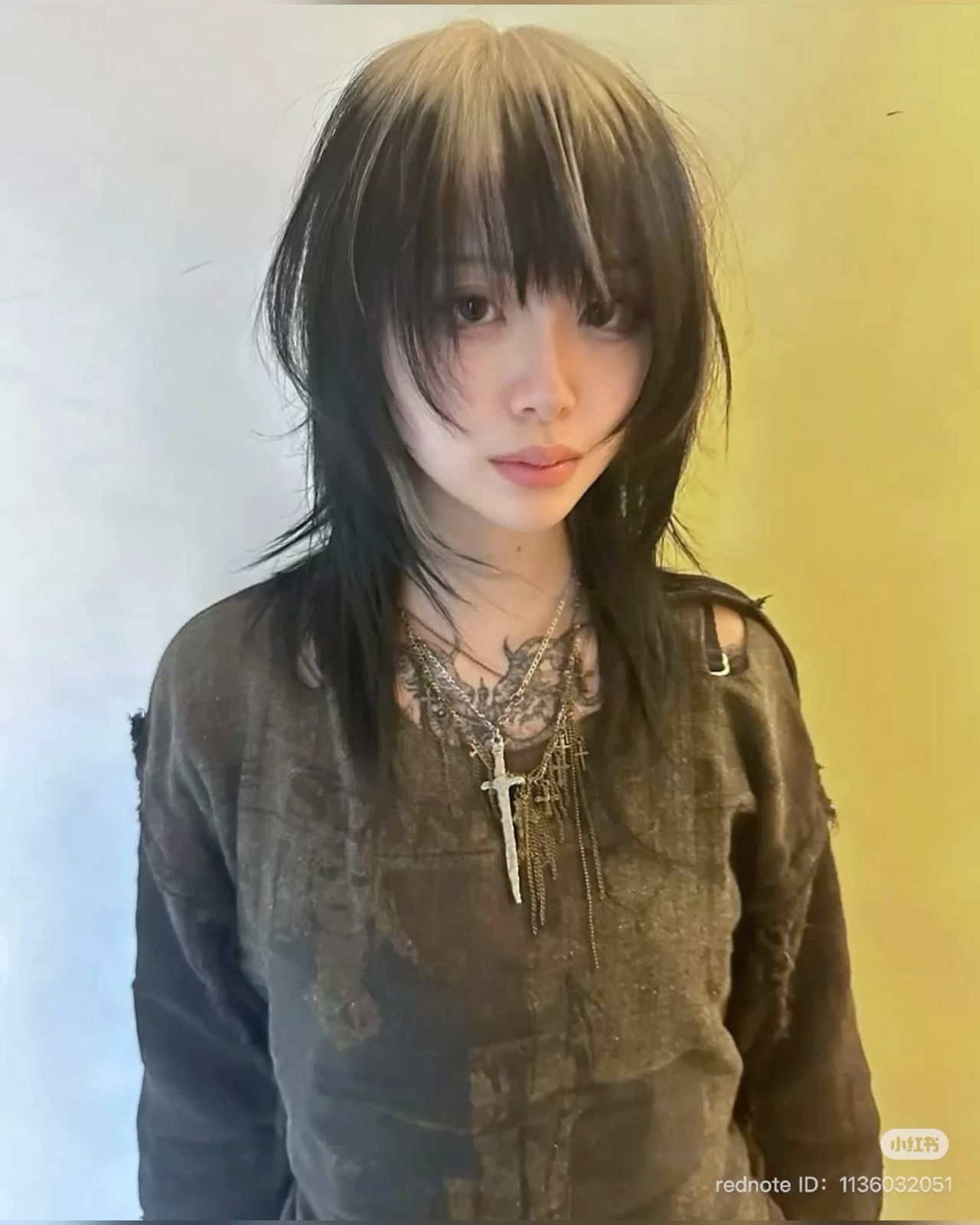 Black wolf cut with a creamy platinum ghost-root section at the center part.