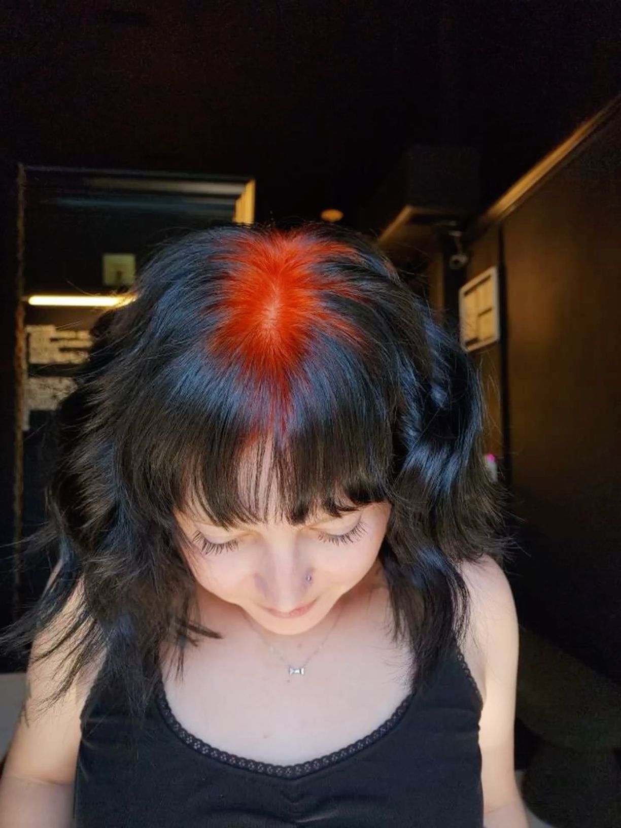 Black wavy bob with a concentrated orange-red ghost-root glow at the crown.