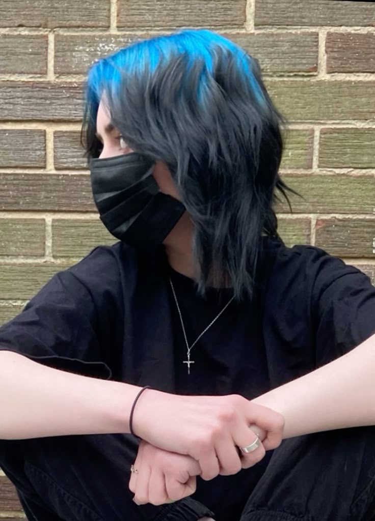 Medium black layered shag with electric blue ghost roots visible across the top side panel.