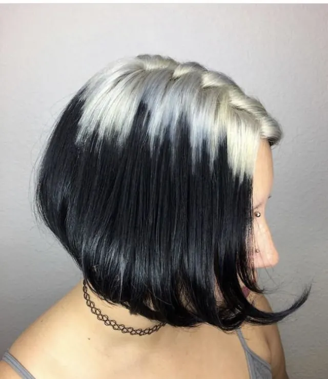 Short black sleek bob with platinum blonde ghost roots visible from the side profile.