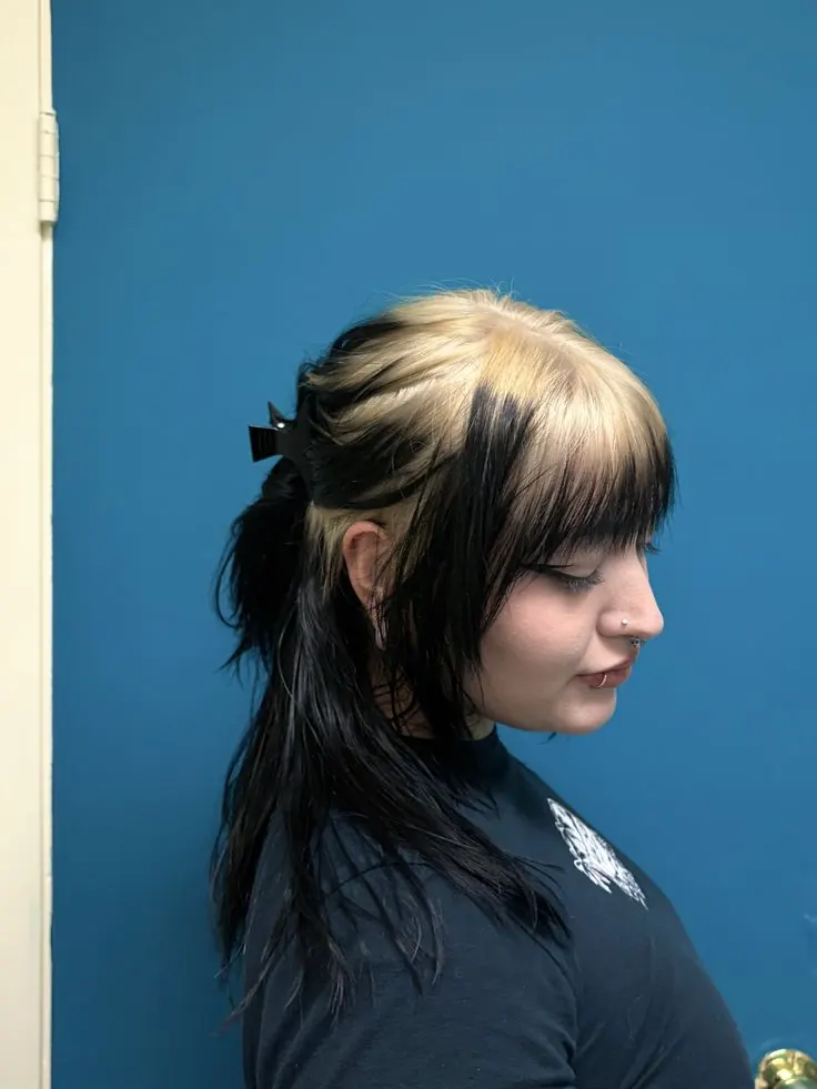 A dark half-up style with taupe blonde ghost roots and a soft fringe.