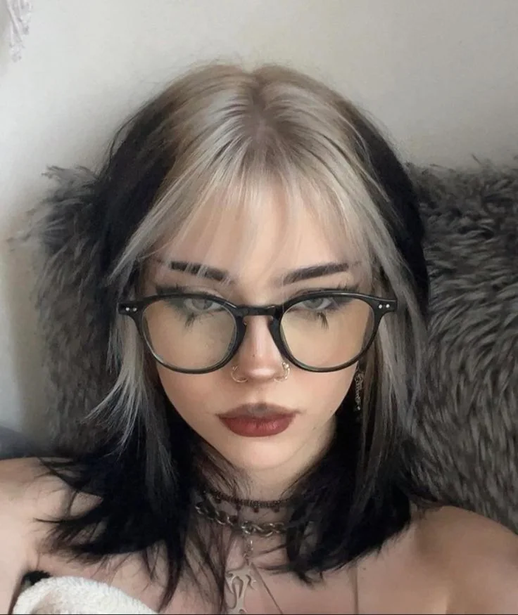Medium messy black shag with wispy bangs and silver-white ghost roots.